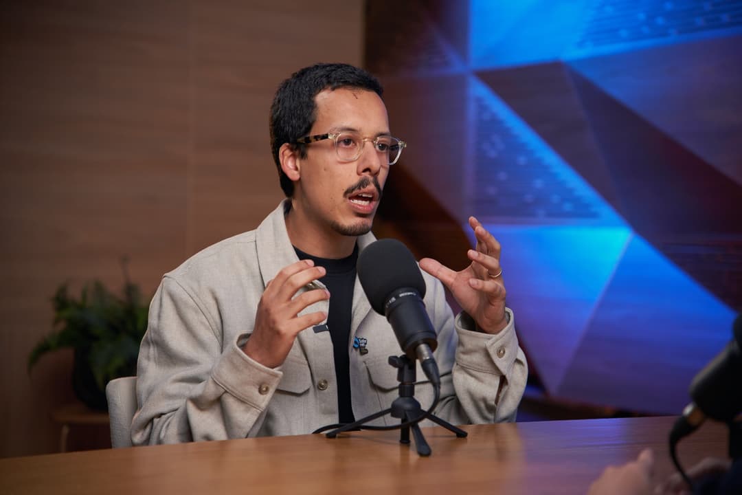Guilherme Alves gesticula enquanto fala ao microfone durante a gravação de uma aula do curso da SaferNet
